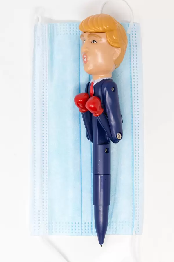 Trump und die Corona-Krise: US-Präsident Kugelschreiber mit Boxhandschuhen auf OP-Maske