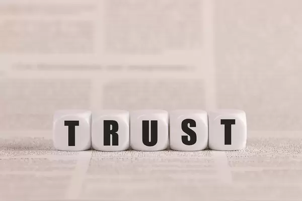 Trust written with cubes on a newspaper