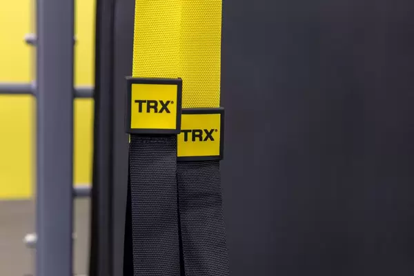TRX Suspension Schlingentrainer für Fitnessübungen, gelb-schwarzer Gurt mit Logoaufdruck auf der Fibo in Köln