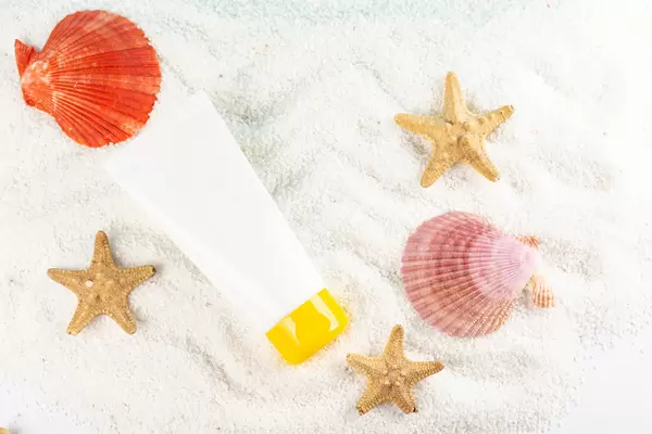 Tube of sunscreen with seashells, top view