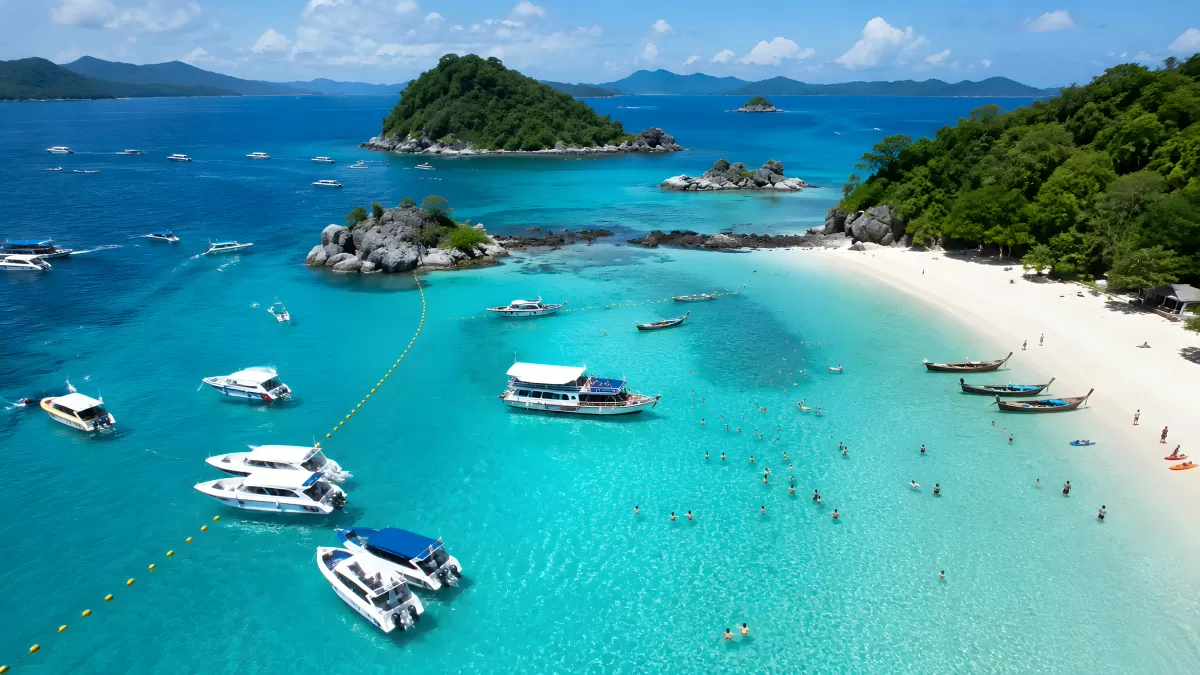 Türkisblaue Bucht mit Booten und weißem Sandstrand