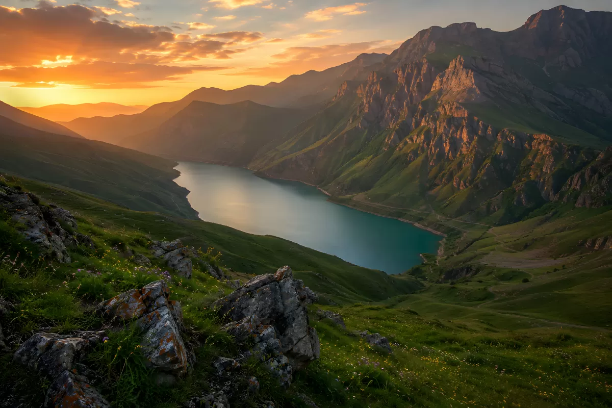 Türkiser Bergsee im Abendlicht mit Gipfelpanorama