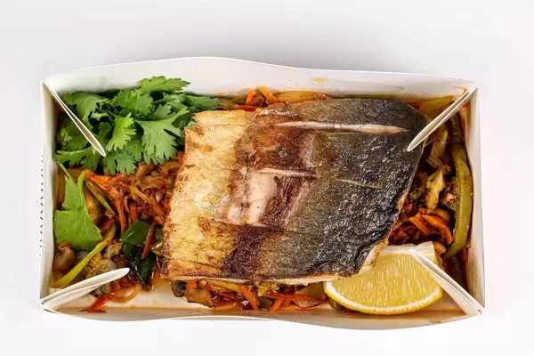 Tuna steaks with vegetable garnish in a cardboard box