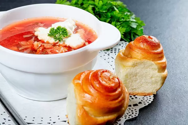 Tureen with beet soup, fresh bread and herbs on the table (Flip 2019)