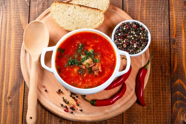Tureen with fresh red borsch on a wooden kitchen Board