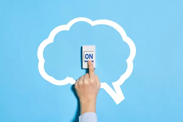 Turn on the brain, switch on your mind - hand pushing ON button in the brain shape