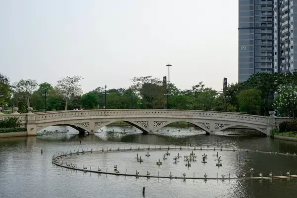Turned Off Fountain System in a Lake at Vinhomes Central Park with Pedestrian Stone Bridge in the Background in Saigon, Vietnam
