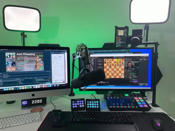Twitch Chess livestreaming from workstation with two monitors, professional microphone, camera, mixing console