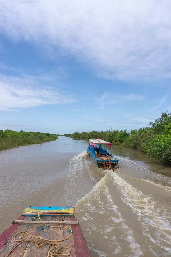 Two Boats driving on a River leading to Tonle Sap Lake in Siem Reap