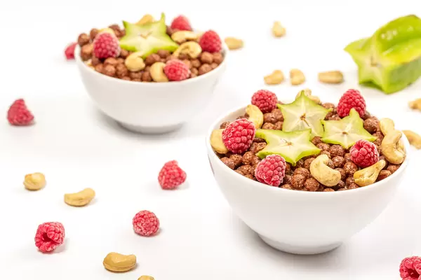 Two bowls with corn balls, nuts and fruits