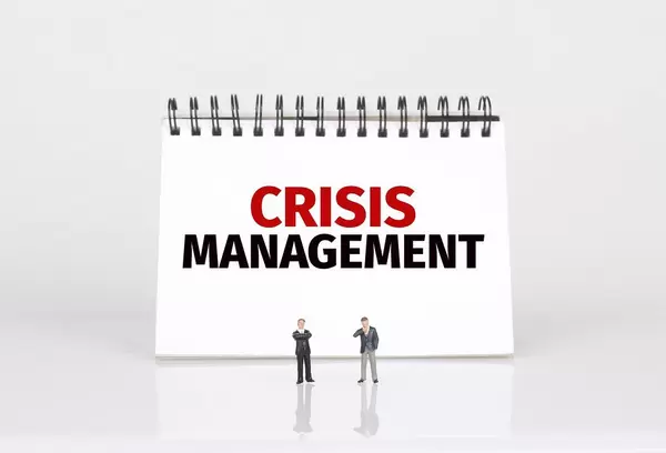 Two businessman standing in front of Crisis Management text