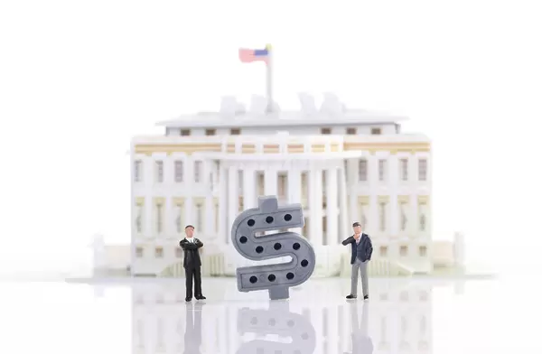 Two businessman standing in front of White House with Dollar sign