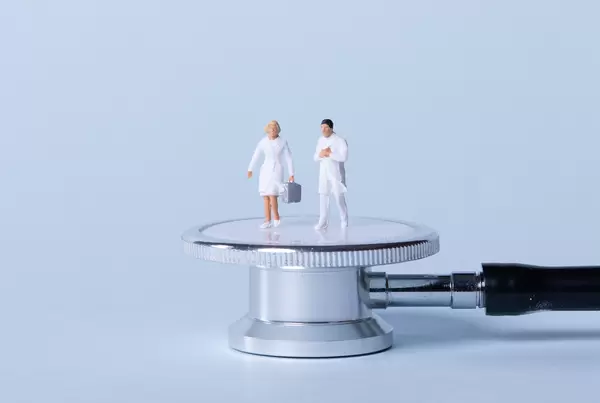 Two doctors standing on stethoscope