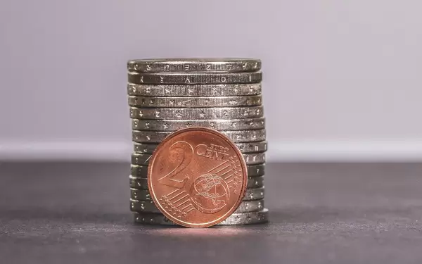 Two Euro cent coin placed in front of piles of Two Euro coins