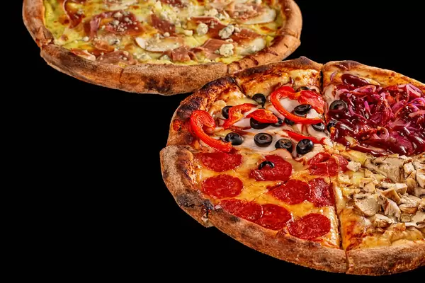 Two fresh hot pizzas on dark background