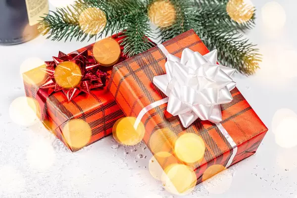 Two gift boxes with ribbons and bows on a background of snow and Golden bokeh (Flip 2019)