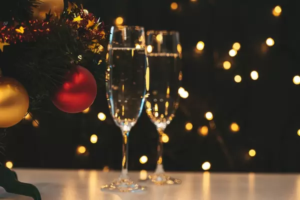 Two glasses of champagne and Christmas tree on a blurry background of a luminous garland (Flip 2019)