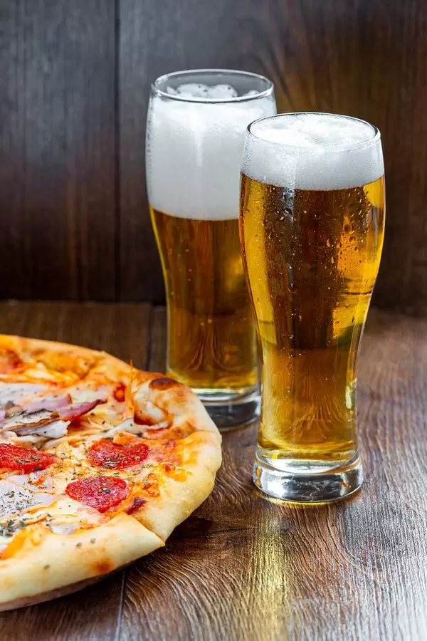 Two glasses of cold beer with pizza