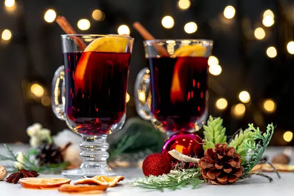 Two glasses of mulled wine with christmas decor and glowing garland background (Flip 2019)