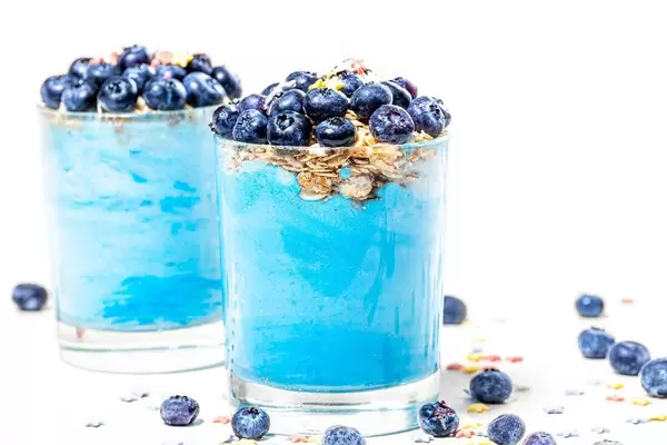 Two glasses with fresh blue smoothies and blueberries (Flip 2019)