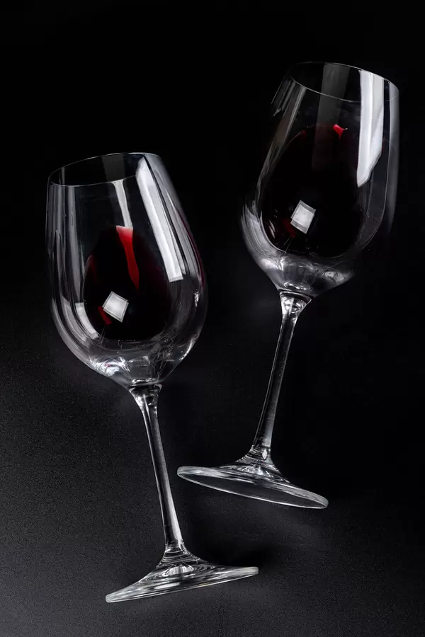 Two glasses with red wine on black background