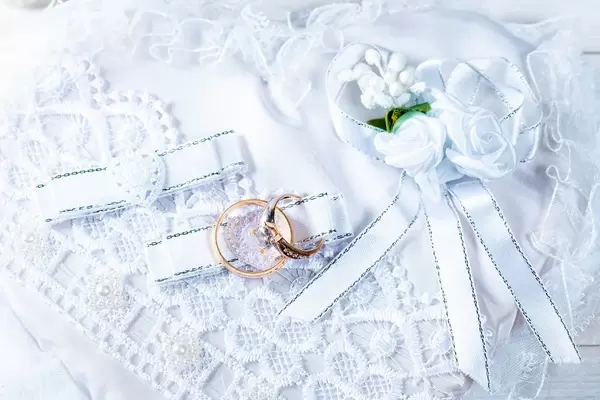 Two gold rings on white lace background