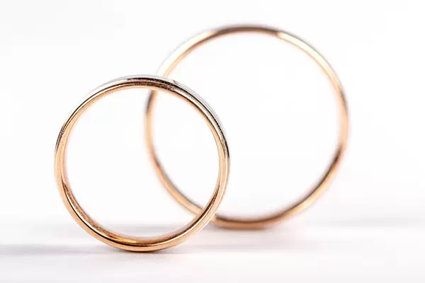 Two gold wedding rings on white