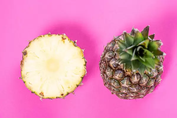Two halves of a ripe pineapple on a pink background (Flip 2019)