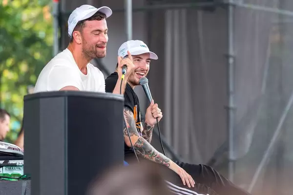 Two happy German Rapper Marteria and Casper on a spontaneous concert sitting on stage