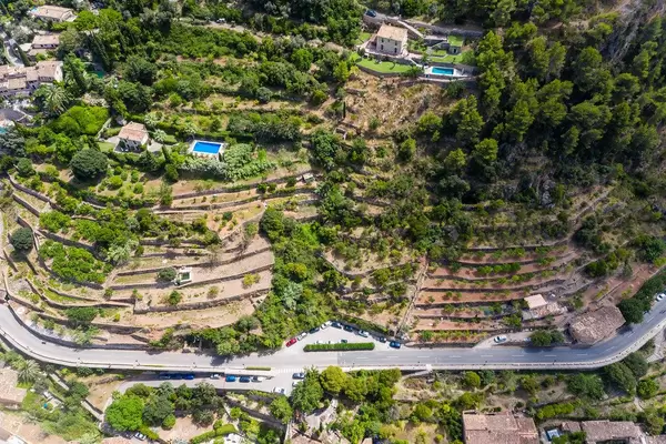 Two houses with pool on top of terraced hills in Deià, in the Serra de Tramuntana on Mallorca. Drone photo