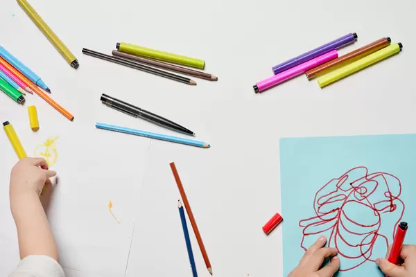 Two kids having fun drawing with colorful pens