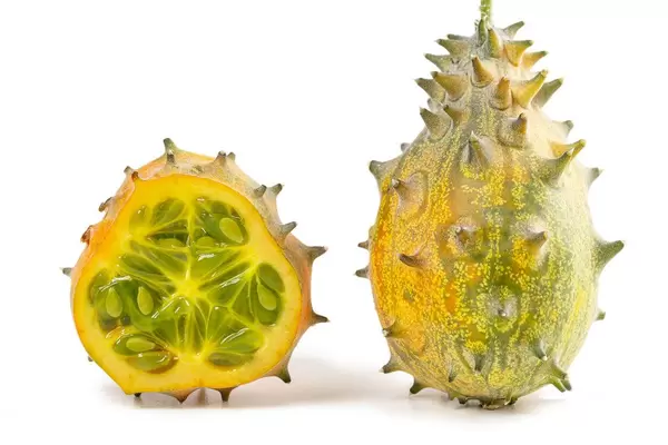Two kiwano or african horned cucumbers, one cut in half