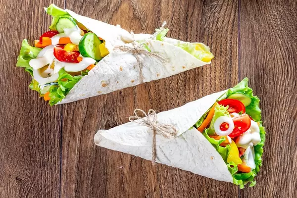 Two lavash cone with vegetable filling on wooden background (Flip 2019)