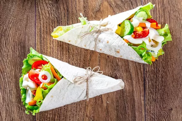Two lavash cone with vegetable filling on wooden background