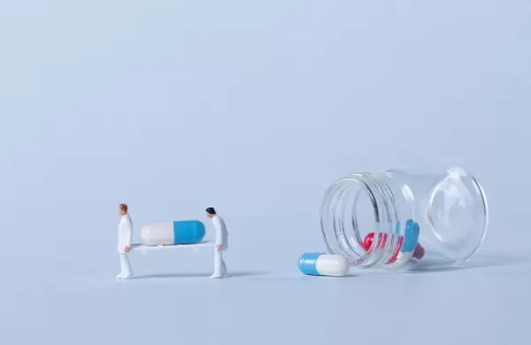 Two medical workers carrying a pills