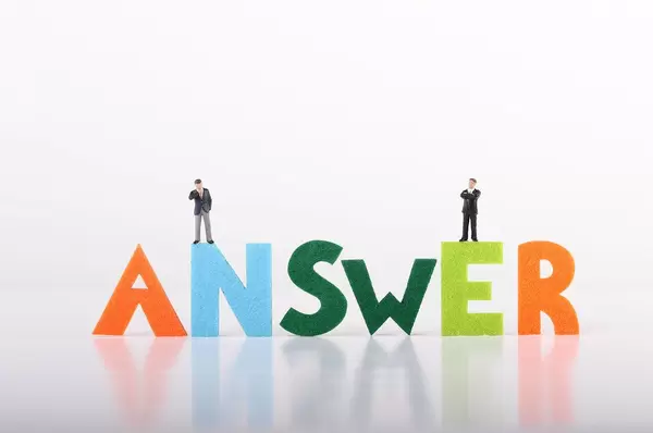 Two miniature businessman with Answer text on white background