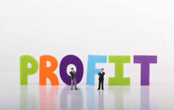 Two miniature businessman with Profit text on white background