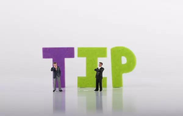 Two miniature businessman with Tip text on white background