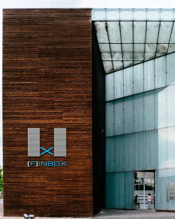 Two people peeking inside Finbox Finnish EXPO 2000 pavilion in Hannover Gelände