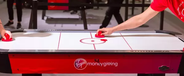 Two people playing air hockey