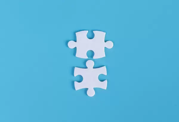Two pieces of jigsaw puzzle on blue background
