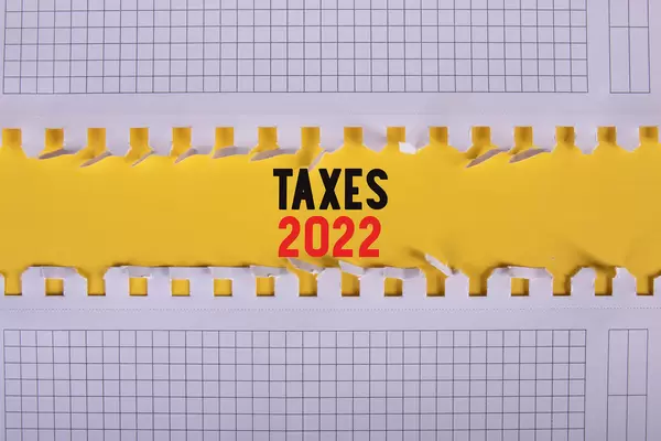 Two pieces of paper with Taxes 2022 text on yellow