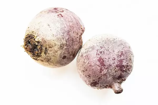 Two raw beetroots on white background