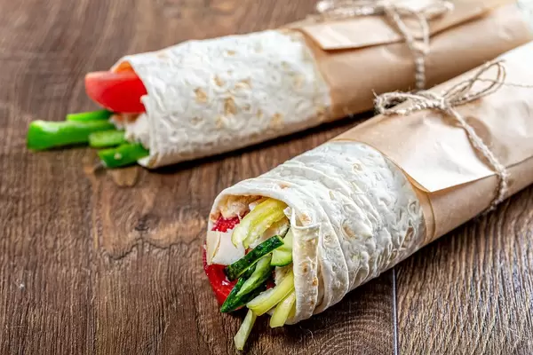 Two ready-made Shawarma on a brown wooden background (Flip 2019)
