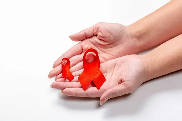 Two red ribbons in the hands of a woman on a white background