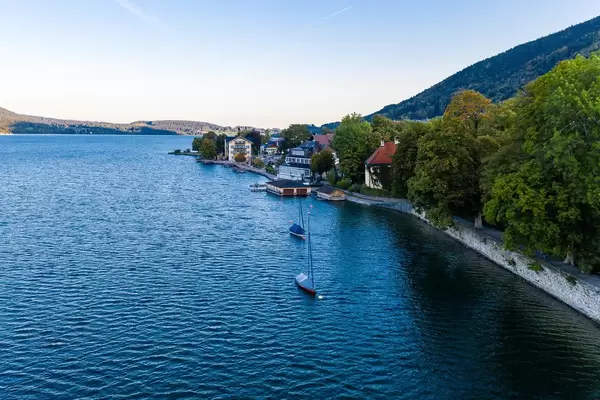 Two sailboats with winter cover parked by the lake promenade at Tegernsee in Bavaria. Drone photo