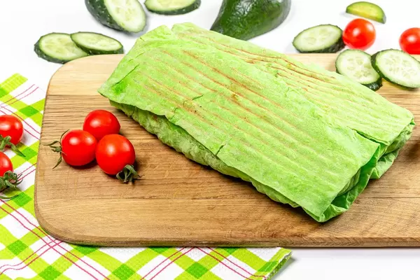 Two Shawarma in green pita bread with vegetables