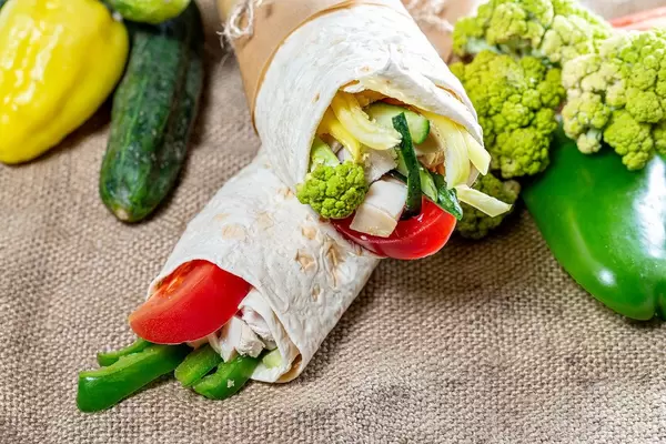 Two Shawarma with fresh vegetables on the background of burlap (Flip 2019)