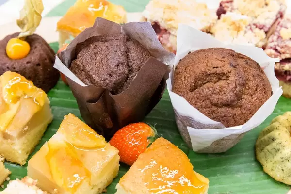 Two small chocolate tartlets next to a strawberry and fruit cake, served as dessert at the Barcamp OMWest19 of AXA in Cologne, Germany