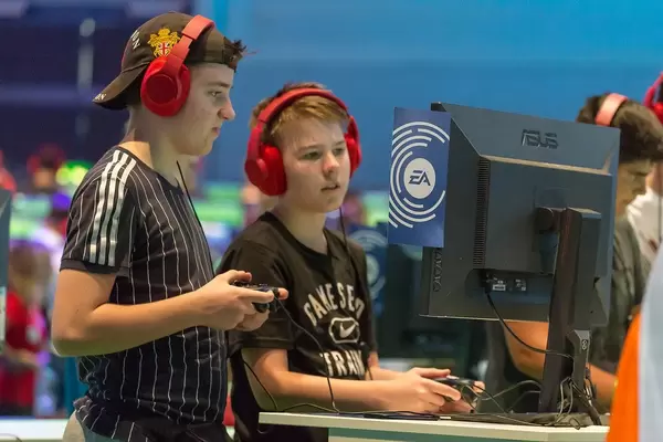 Two teenagers playing FIFA19 at the Gamescom 2018 fair in Cologne